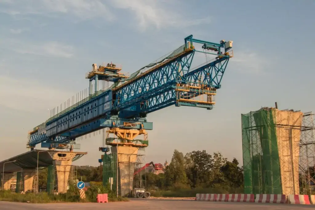 Bridge construction with a blue gantry crane, showcasing material take-off services in infrastructure.