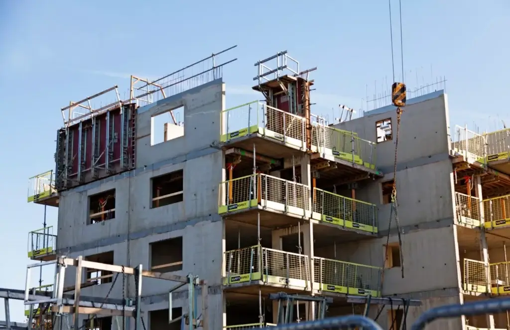 Construction site with building under construction and safety barriers in place.