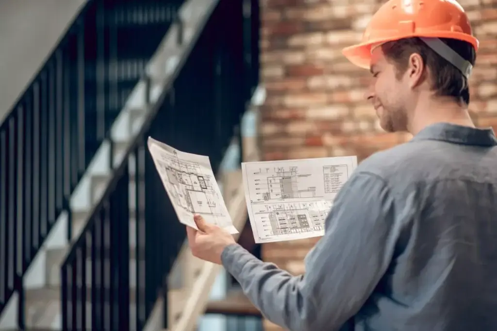 Construction worker reviewing blueprints for openings estimating services